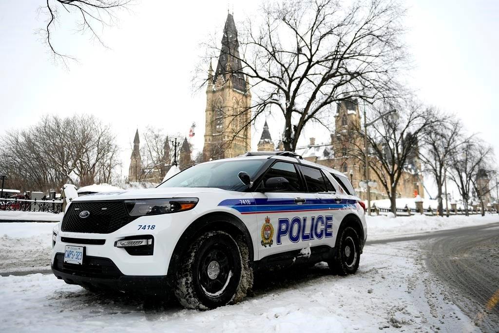 An Ottawa Police officer sits in their cruiser on Wellington Street below Parliament Hill in Ottawa -THE CANADIAN PRESS/Justin Tang